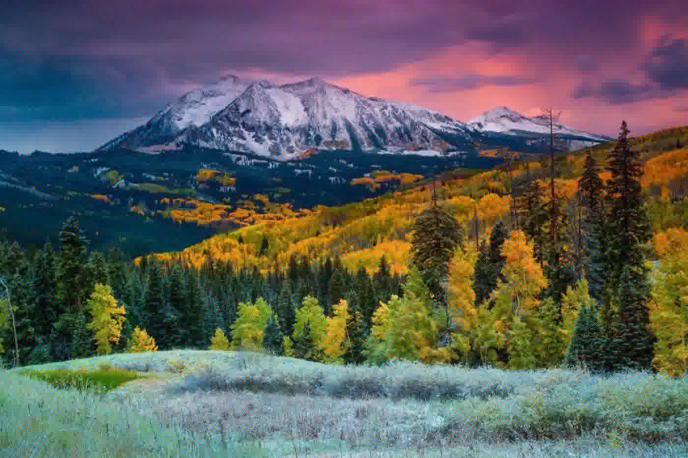 First snow on the peaks above frosted meadows and blazing aspens near Kebler Pass