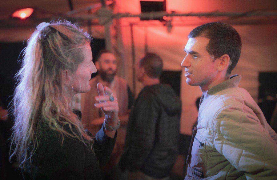 Two participants in deep conversation at an evening gathering